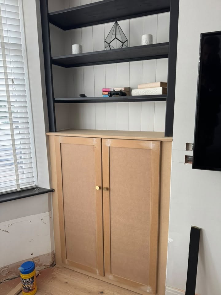 New alcove cabinet with black shelves above, doors ready for paint