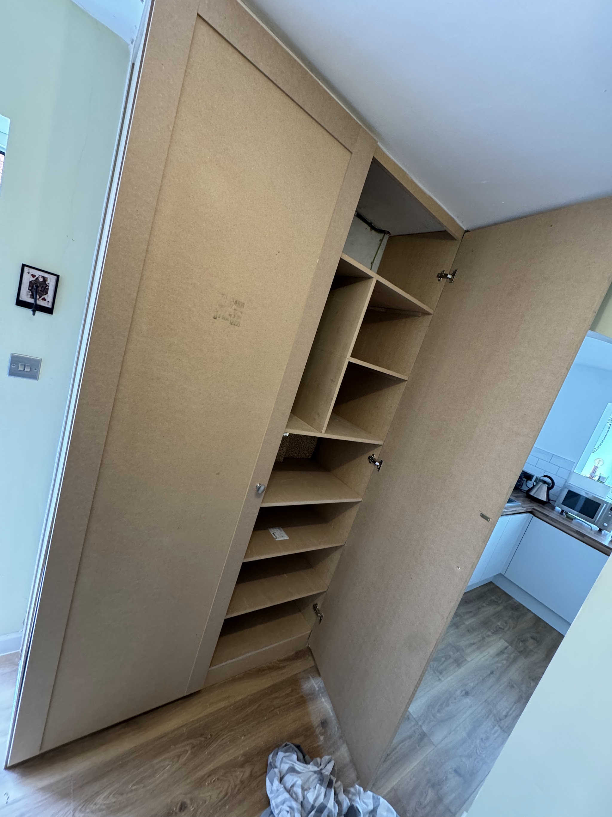 Floor to ceiling cabinet with open shelving built into a room