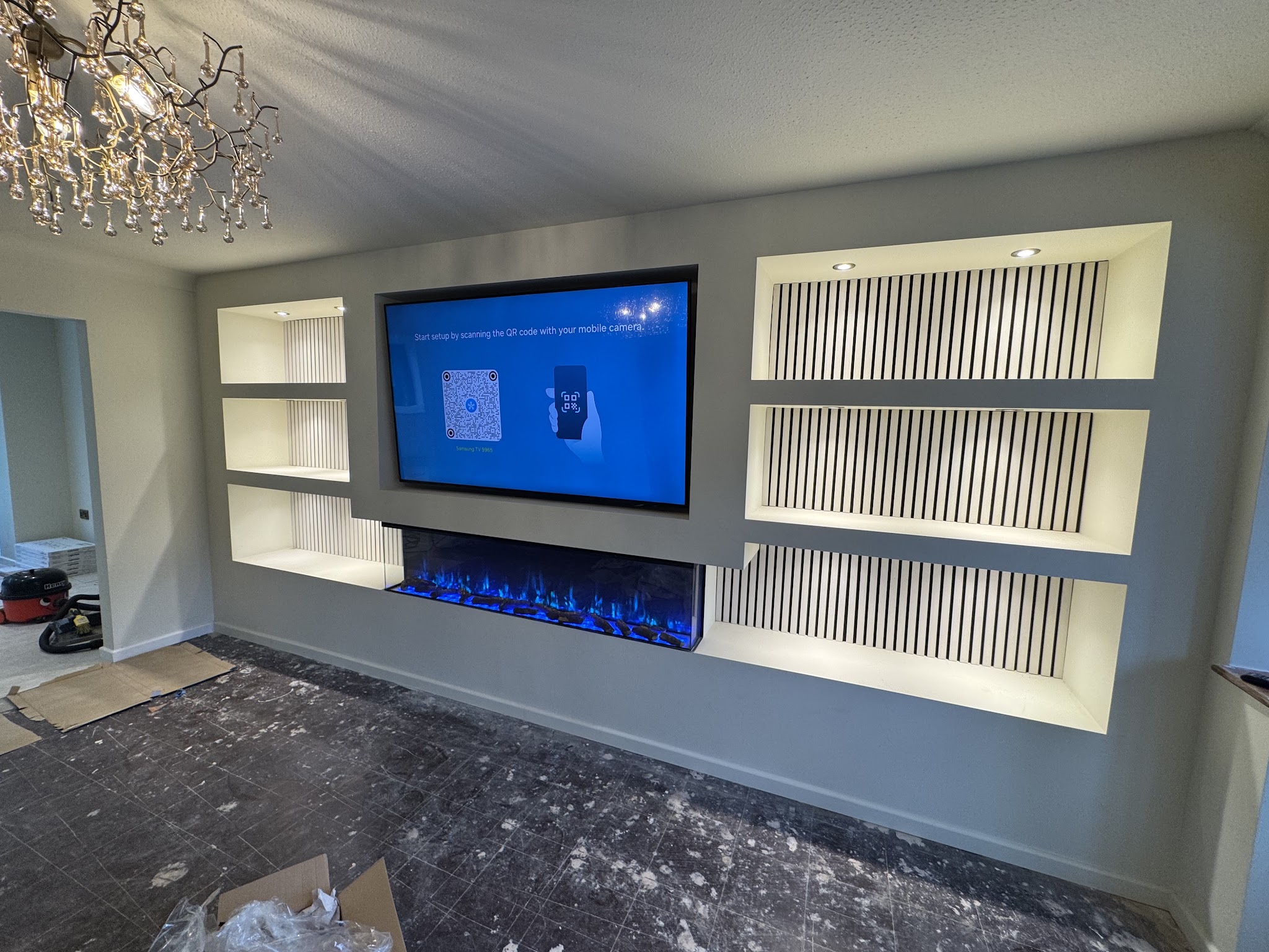 Finished media wall with a built-in electric fire and lit slatted alcoves
