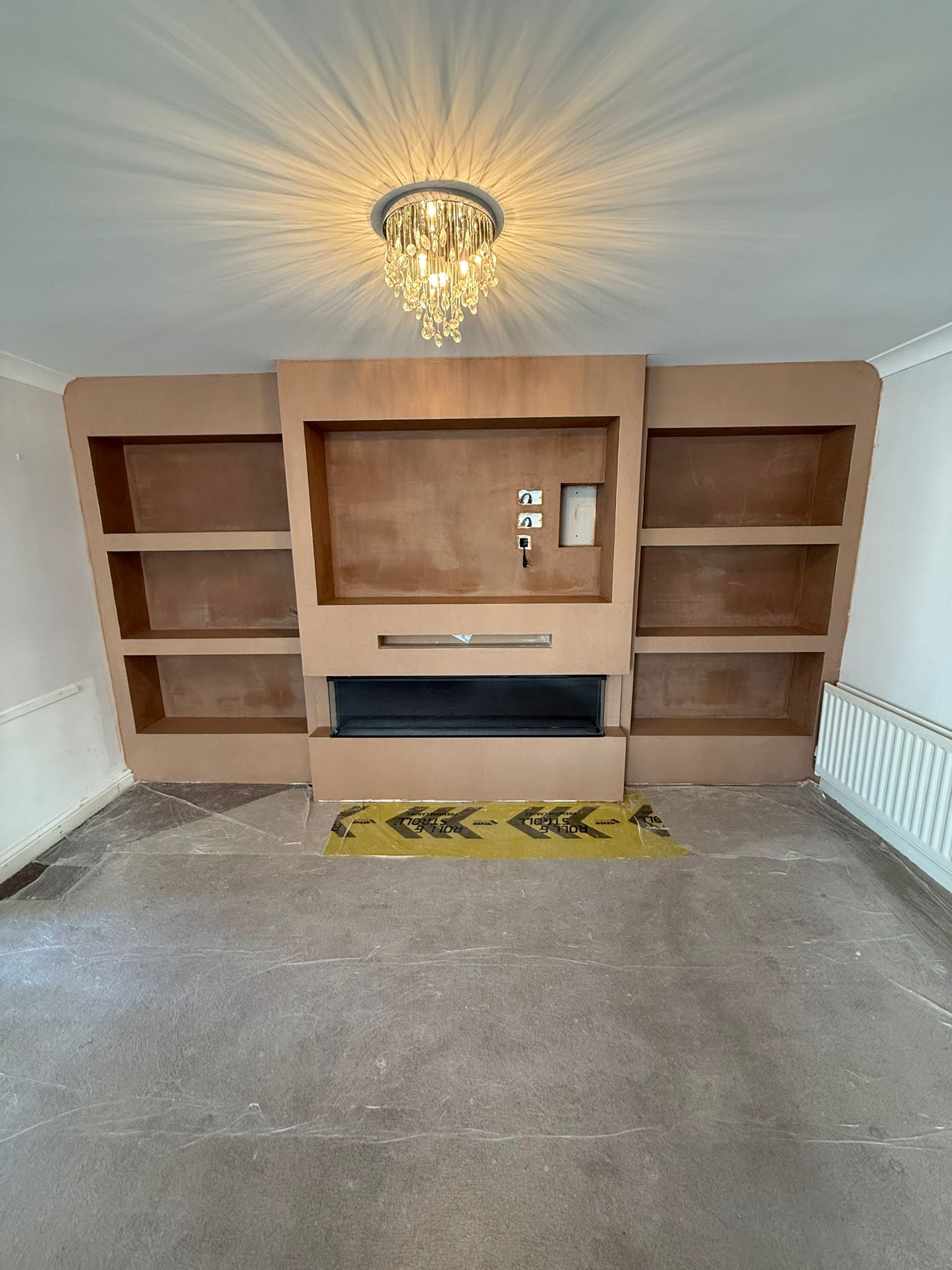 Media wall frame with shelving and a fire recess under construction
